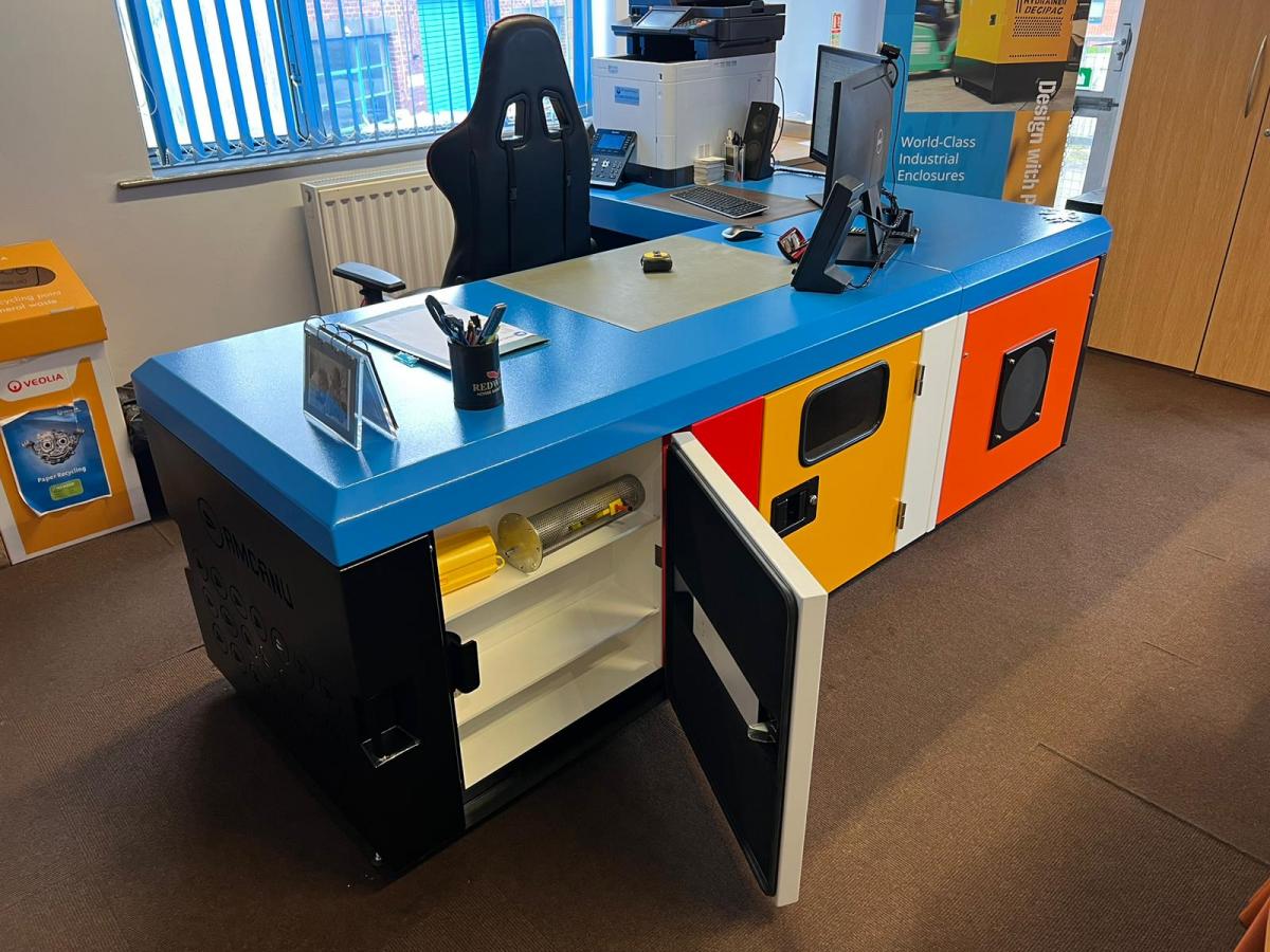 A colourful desk in an office with a door open.