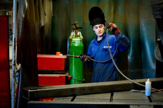 Apprentice with welding torch