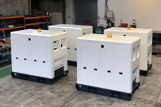 4 white metal battery storage enclosures in a factory