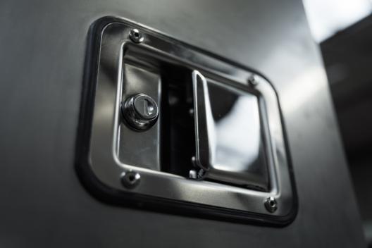 A close up of an enclosure door handle in the Amcanu factory.